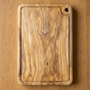 The Alba Olive Wood Carving Board with Juice Groove seen from above, the full grain readable