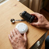 Top view: the round white controller with its single button, the coil and its jack plug, the measuring spoon