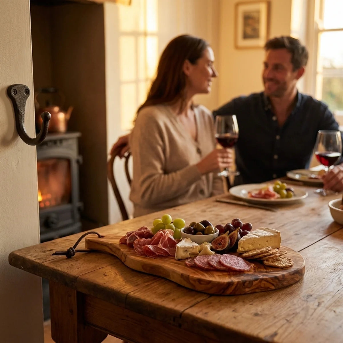 The Alba Olive Wood Board with Leather Loop in use on a dining table