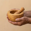 The Alba Olive Wood Mortar and Pestle held in two hands, showing its size
