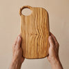 The Alba Olive Wood Board with Grip Hole held in two hands, showing its size
