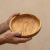 The Alba Olive Wood Bread Bowl held in two hands, showing its size