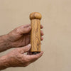 The Alba Olive Wood Pepper Mill held in two hands, showing its size