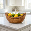 The bowl on a kitchen island filled with lemons and limes