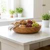 The Alba Olive Wood Bread Bowl in use on a kitchen island