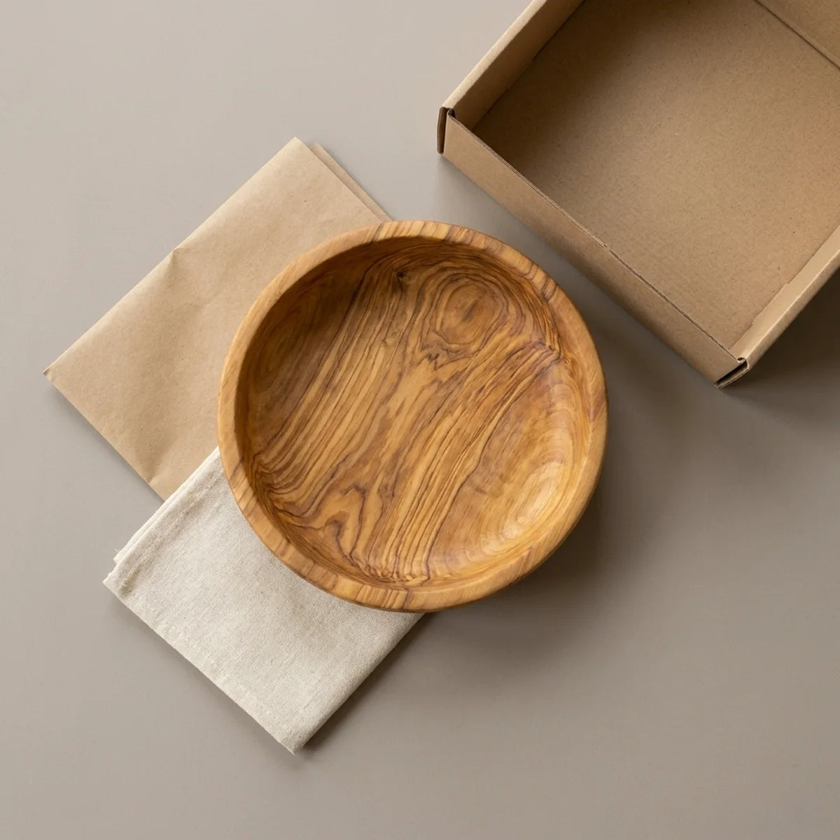 The Alba Olive Wood Bread Bowl with its kraft wrapping and plain shipping box